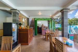 a restaurant with wooden tables and chairs and a counter at Sekumpul Guest House in Sudaji +44 photos