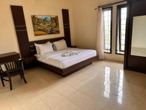 a bedroom with a bed and a desk and window at Telaga Villa Siki in Mantaak +21 photos