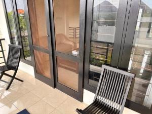 a balcony with two chairs and a glass door at Telaga Villa Siki in Mantaak
