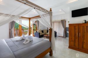 a bedroom with a canopy bed with a towel on it at Sekumpul Guest House in Sudaji