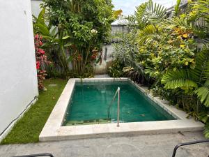 a swimming pool in the middle of a garden at Telaga Villa Siki in Mantaak