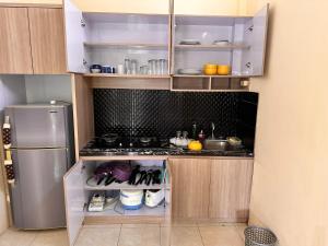 a small kitchen with a stove and a refrigerator at Telaga Villa Siki in Mantaak