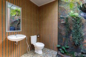 a bathroom with a toilet and a sink at Sekumpul Guest House in Sudaji +47 photos