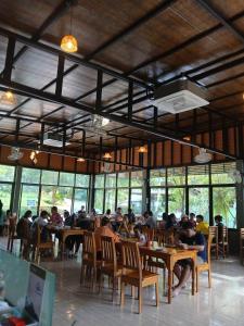 a group of people sitting at tables in a restaurant at Khao Sok River Canoe&Resort in Khao Sok National Park
