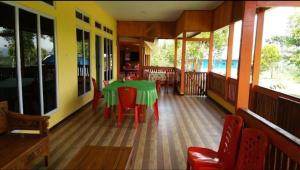 a dining room with a green table and red chairs at Ruteng YosPrima Garden in Lao