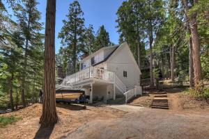 a large white house with a boat in front of it at Yama Cabin - 5 min walk to the village, EV plug, hot tub, kid & pet friendly in Lake Arrowhead