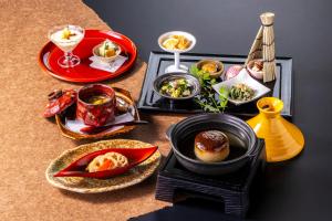 a table with plates of food on a table at Tokiwa Hotel in Kofu