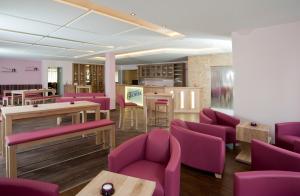 沃姆斯的住宿－安什洛斯帕克別墅酒店，一间设有紫色椅子和桌子的等候室