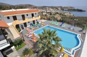 an overhead view of a swimming pool with chairs and umbrellas at Pennystella Apartments in Agia Pelagia