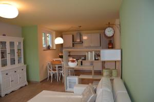 een woonkamer en keuken met een bank en een klok bij Ferienwohnung an der Elbe in Dresden