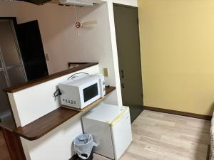 a microwave sitting on a counter in a kitchen at アルピエf 103号室 無料WiFiあります生活しやすい場所です in Kumamoto