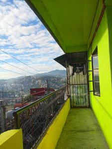 a yellow building with a balcony with a view at iya lee guest hauz in Capissayan