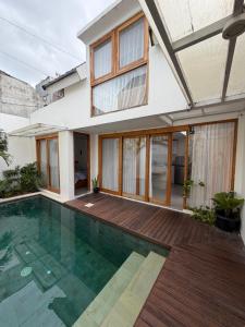 a house with a swimming pool in front of a house at Coconut Villa in Kerobokan