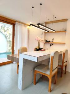 a dining room with a table and chairs with flowers on it at Coconut Villa in Kerobokan