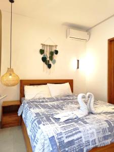 two swans sitting on a bed in a bedroom at Coconut Villa in Kerobokan +22 photos