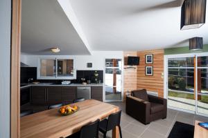 cocina y comedor con mesa de madera en Les Granges de Leo en Aston