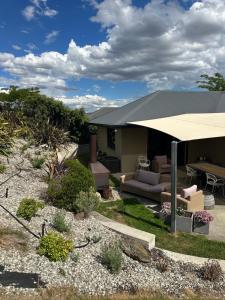a patio with a couch and an umbrella in a yard at The Garden Room in Clyde
