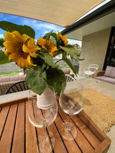 two wine glasses and a vase of sunflowers on a table at The Garden Room in Clyde