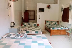 een kamer met 2 bedden en een tv. bij Hai Anh Guesthouse in Phu Quoc