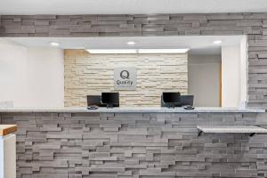 a lobby with a stone wall with two chairs at Quality Inn Beaver I-15 in Beaver