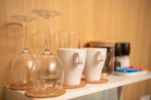 a shelf with wine glasses and cups on it at The Orchard View by Tiny Away in Nashdale