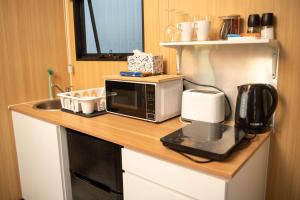 a kitchen counter with a microwave and a coffee maker at The Orchard View by Tiny Away in Nashdale