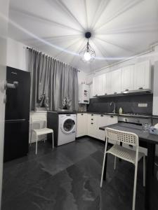 a kitchen with white cabinets and a table and chairs at Apart 1 Dragonul Rosu - Spital Fundeni in Dobroeşti