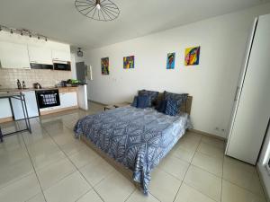 a bedroom with a bed and a kitchen at Studio Bellepierre, vue mer in Saint-Denis