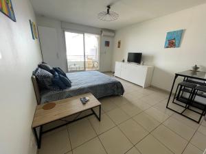 a bedroom with a bed and a table in it at Studio Bellepierre, vue mer in Saint-Denis