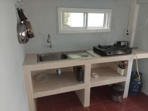 a kitchen counter with a sink and a stove at Mountain View Garden House in Ban Chong Phli