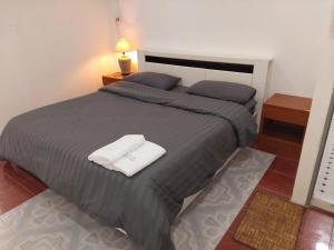 a bedroom with a bed with two towels on it at Mountain View Garden House in Ban Chong Phli