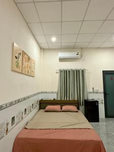 a bedroom with a bed with two pink pillows at Thùy Vinh Homestay in Phú Quốc