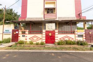 a house with a red door on a street at MAS Residency Home in Pudukkottai