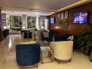 a waiting room with blue chairs and a tv at Sparr Hotel in Amman