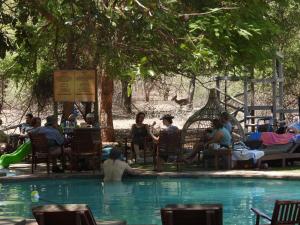 a group of people sitting around a swimming pool at Shelanti Game Reserve in Marken
