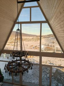 a chandelier hangs in front of a large window at SkyHouse Shahdag in Əniq