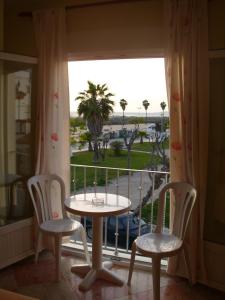 1 mesa y 2 sillas en una habitación con ventana en Hostal Sonrisa del Mar, en Conil de la Frontera