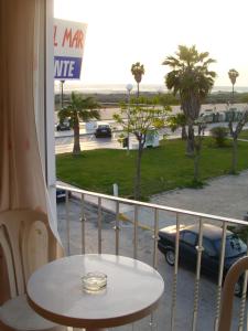 a balcony with a table and a view of a parking lot at Hostal Sonrisa del Mar in Conil de la Frontera