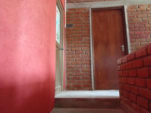 a red brick building with a wooden door at Manilal in Battaramulla