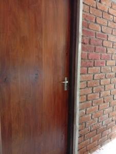 a wooden door on a brick wall at Manilal in Battaramulla