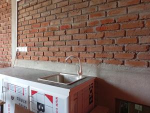 a kitchen sink in front of a brick wall at Manilal in Battaramulla
