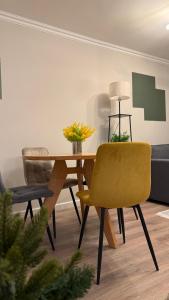 a dining room with a table and a yellow chair at LIZA Home in Jermuk