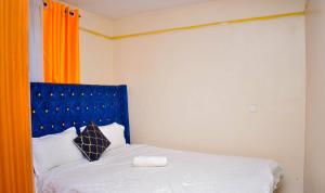 a bedroom with a bed with a blue headboard at Cozy Homes in Thika