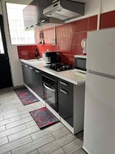 a kitchen with a stove and a refrigerator at Le repaire de la mare in Salazie