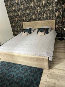 a large wooden bed with two pillows on it at Le repaire de la mare in Salazie