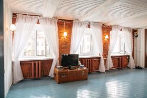 a room with a tv on a table and windows at Studio on Morskaya 25 in Saint Petersburg