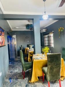 a dining room with two tables and green chairs at JEVENOM HOTEL in Ibafo