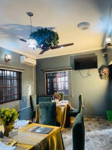 a dining room with tables and chairs and a tv at JEVENOM HOTEL in Ibafo +17 photos