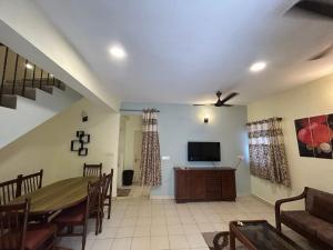 a living room with a table and a television at The golden villa in Calangute +10 photos