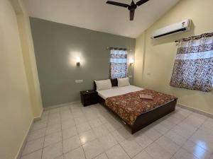 a bedroom with a bed and a ceiling fan at The golden villa in Calangute